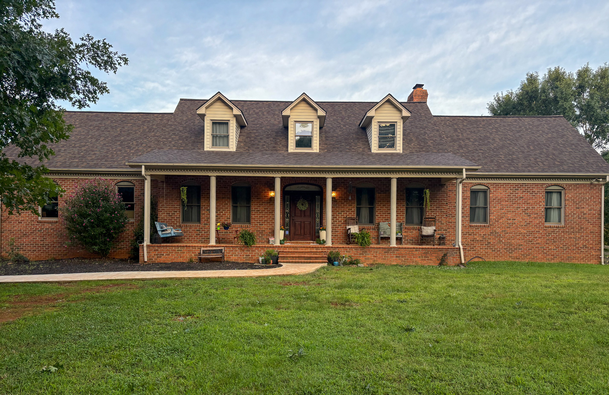Large brick home with a covered front porch and expansive yard, belonging to Sponsored Residential Provider Mary Salvia in Lynchburg, Virginia.