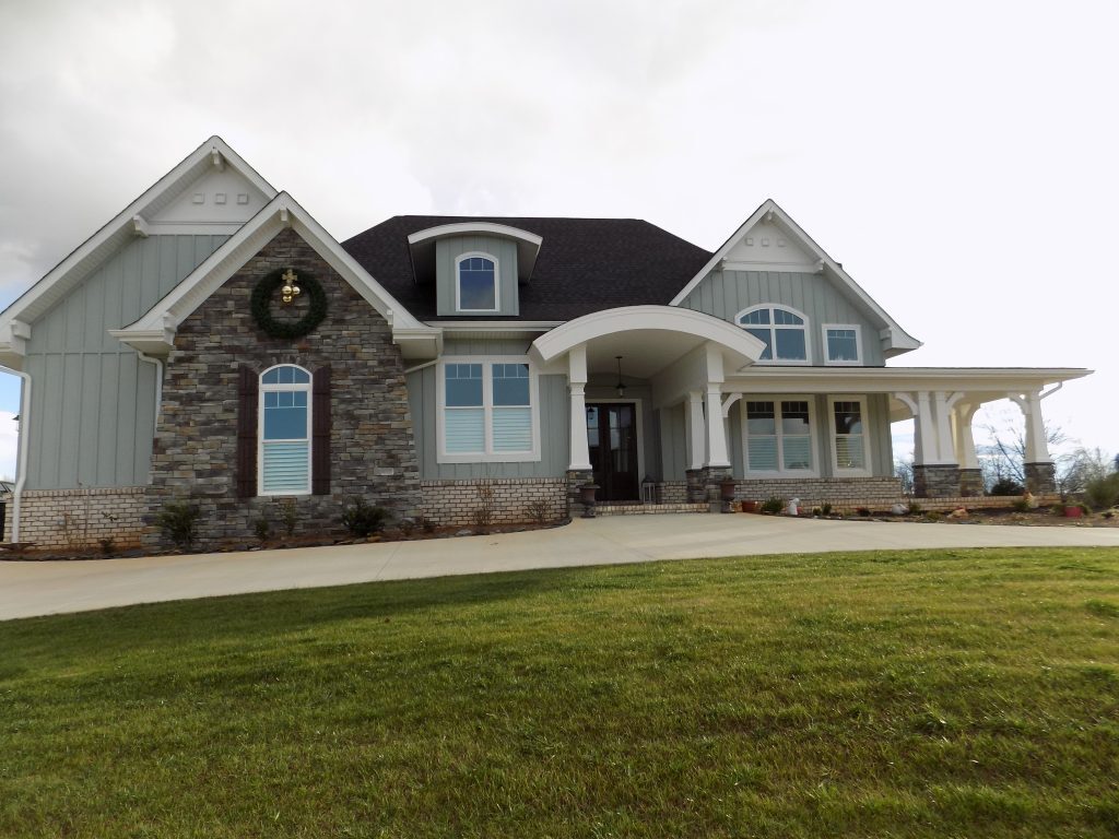 Large gray and stone house with arched entryway, dormer windows, and a wide front lawn belonging to Group Home Provider Michelle Gebetsberger in Forest, Virginia.
