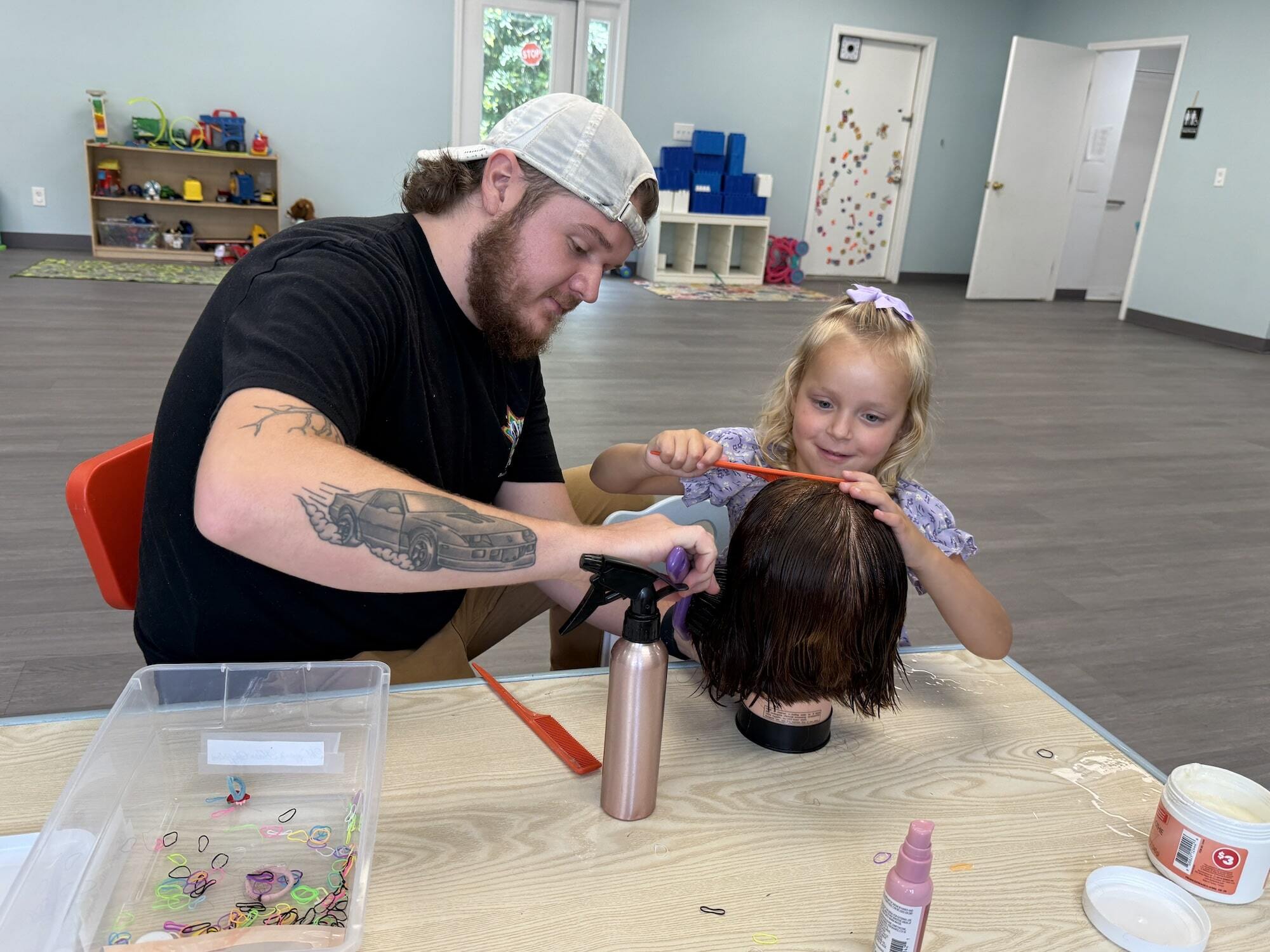 Man and girl styling a doll's hair