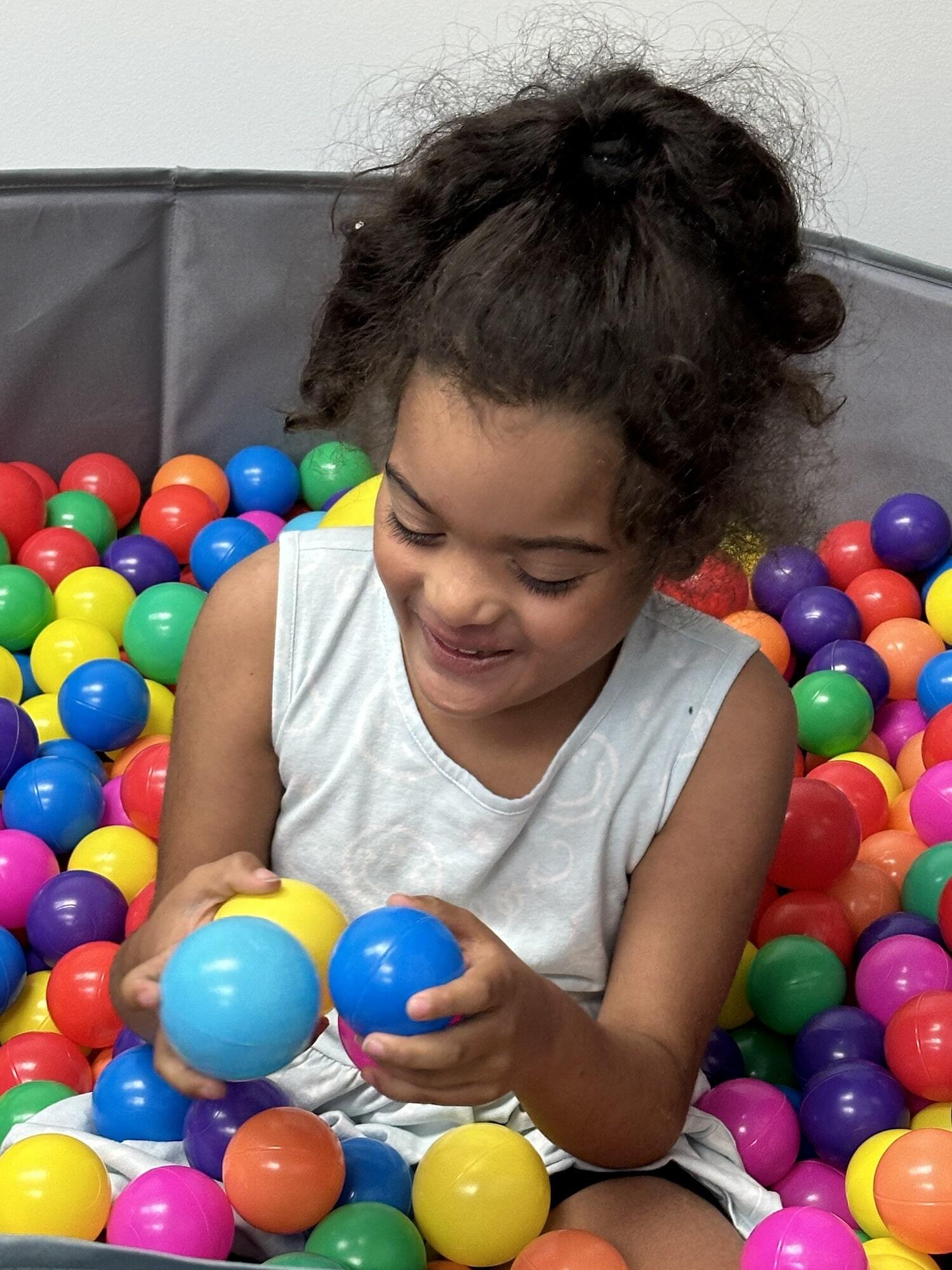 Girl playing in a ball pit