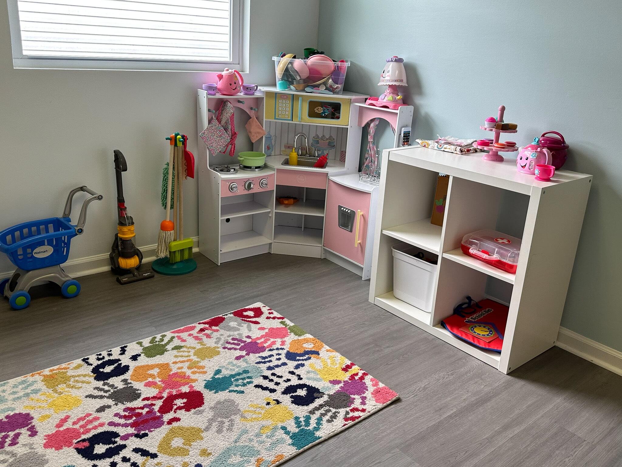 Play area in the Salem ABA Center with toys and a colorful handprint carpet